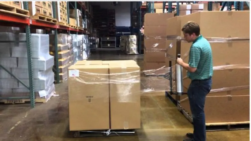 Nhân viên kiểm tra pallet hàng đã bọc màng