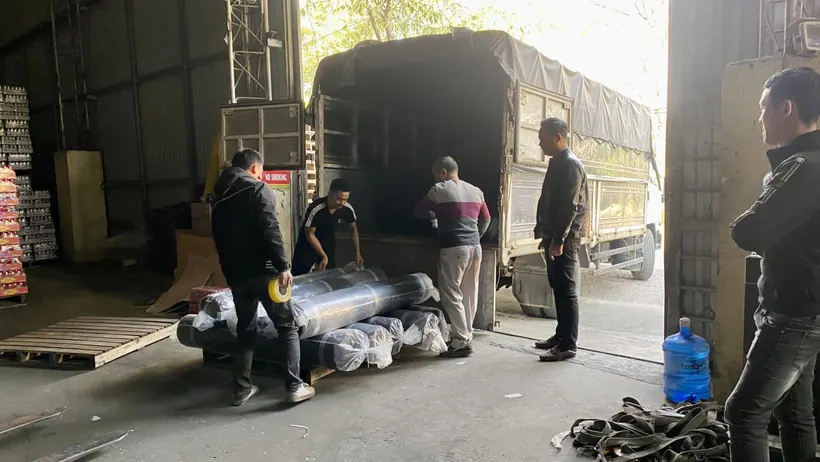 Nhân viên đưa kiện hàng ra khỏi thùng xe