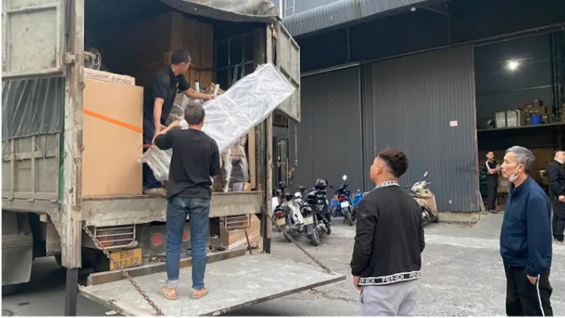 Nhân viên phối hợp đưa hàng ra khỏi thùng xe